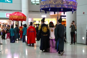 Royal Walk: Passengers take note, and photos, as reenactors begin their procession at Incheon International Airport.