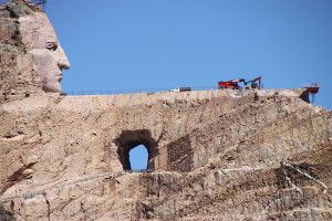 The far-from-completed granite sculpture of Crazy Horse, with large machinery clearly visible at the level where the arm will be.