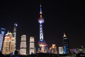 Part of the Shanghai skyline, seen at night, with the Oriental Pearl Tower prominent on the horizon.