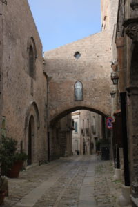 One of Erice’s medieval streets, bracketed by low-rise stone buildings, paved with well-worn stones and made still more evocative of other eras with a religious icon at the top of its overpass.