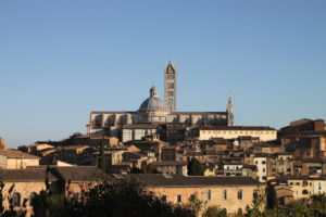 View of the Siena cityscape with the cathedral in the background, perched atop one of the city’s three hills.