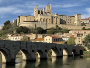 Above, sweeping view of Beziers with its cathedral as the centerpiece at top and the town’s medieval bridge in the foreground. Below, closer in, La Prison Hotel in the foreground, with Beziers Cathedral in the background.