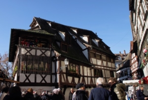Half-timbered houses overlook the Christmas market in La Petite France, an area of Grande Ile where tanners once worked. In photo at bottom, market goers explore shopping choices.